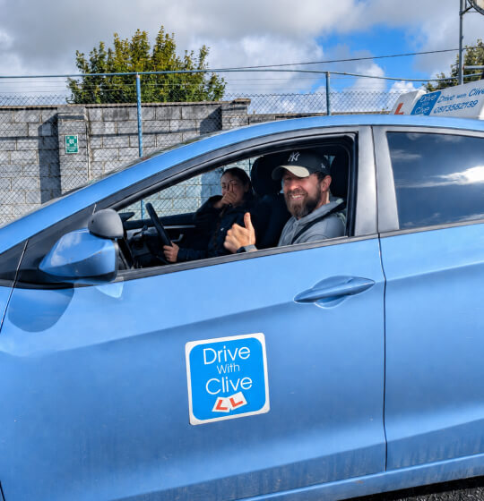 Drive with Clive instructor and learner giving a thumbs up during a driving l...