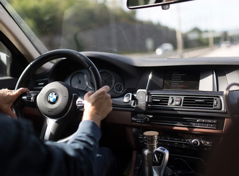 Driver holding the steering wheel while travelling on an open road