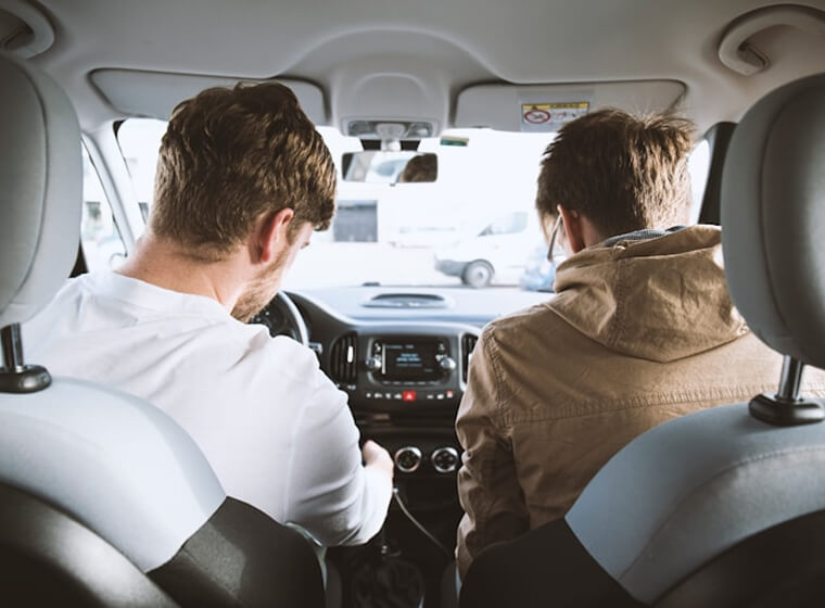 Driver and passenger inside a car during a driving lesson for new drivers